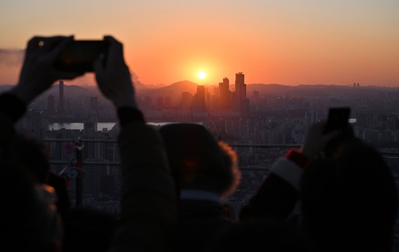 People in Seoul, South Korea, take pictures as they observe the last sunset of the year. Jung Yeon-Je/AFP/Getty Images